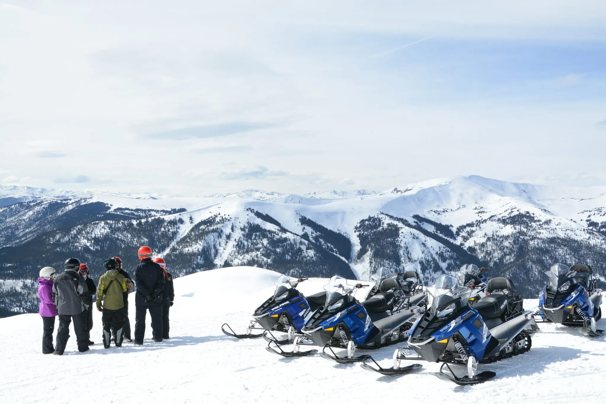Group of riders on guided snowmobile tour near Keystone Colorado with mountain views