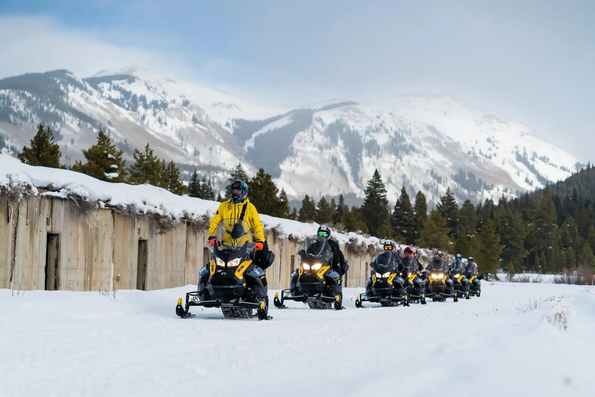 Line of snowmobile riders on self-guided rental at Vail Pass near Keystone, Colorado.